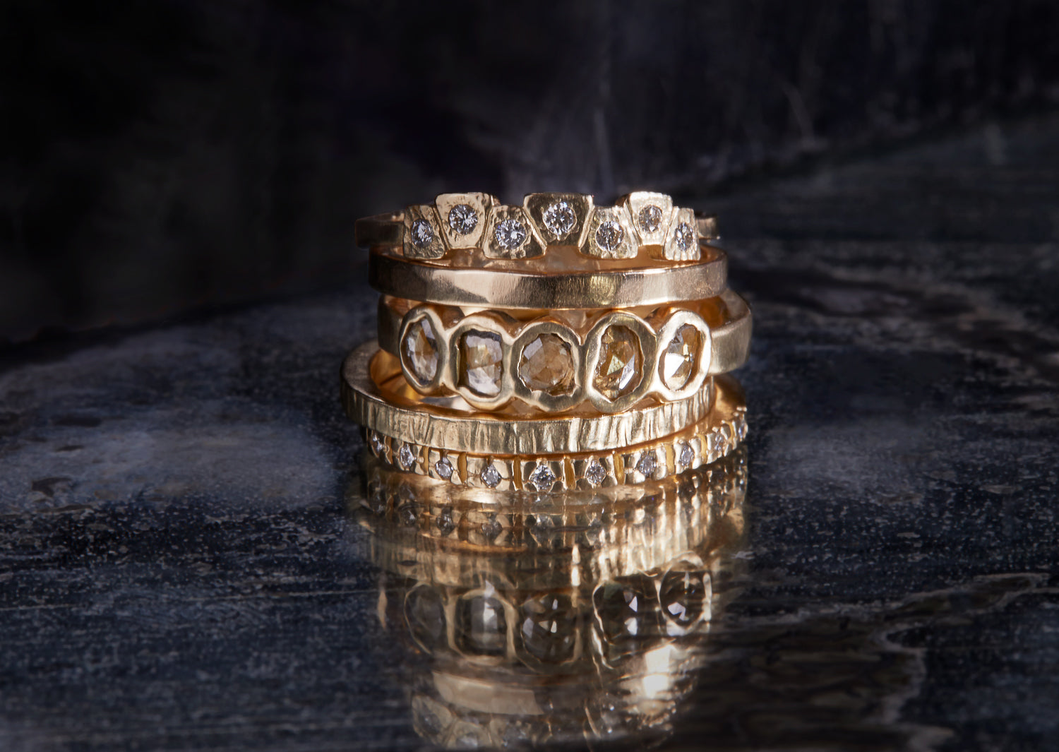 The Coral ring features 7 white diamonds flush set in textured 14k gold, with a hammered band.