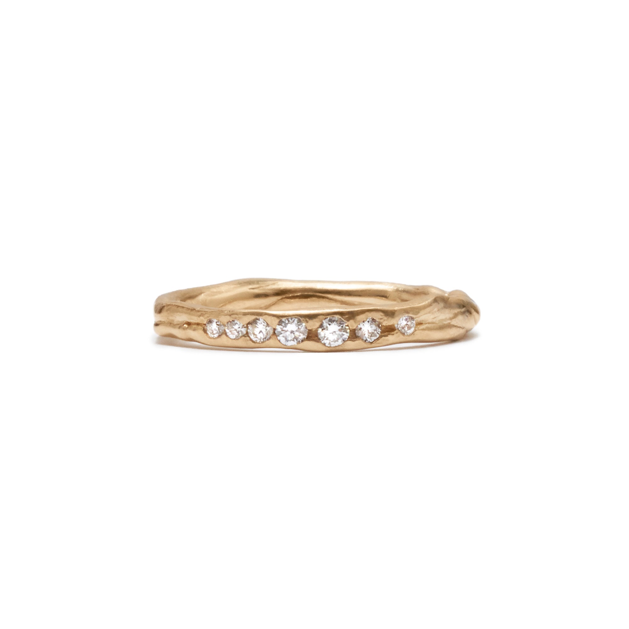 The unique Barrier band showcases seven graduated white diamonds, set across the front of an organic 14k band