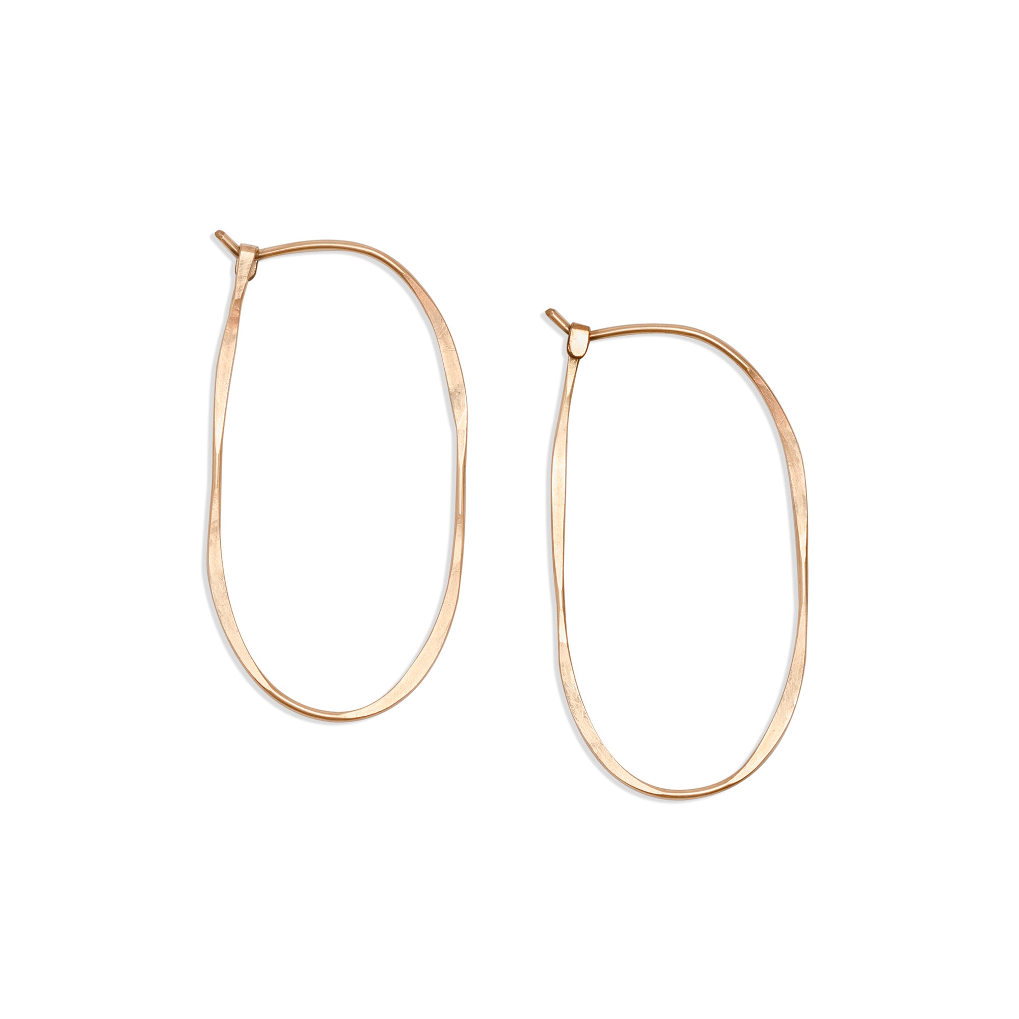 Elongated Oval Hoop, a handmade modern hoop earring made from hammered 14k gold wire finished with a hook closure.