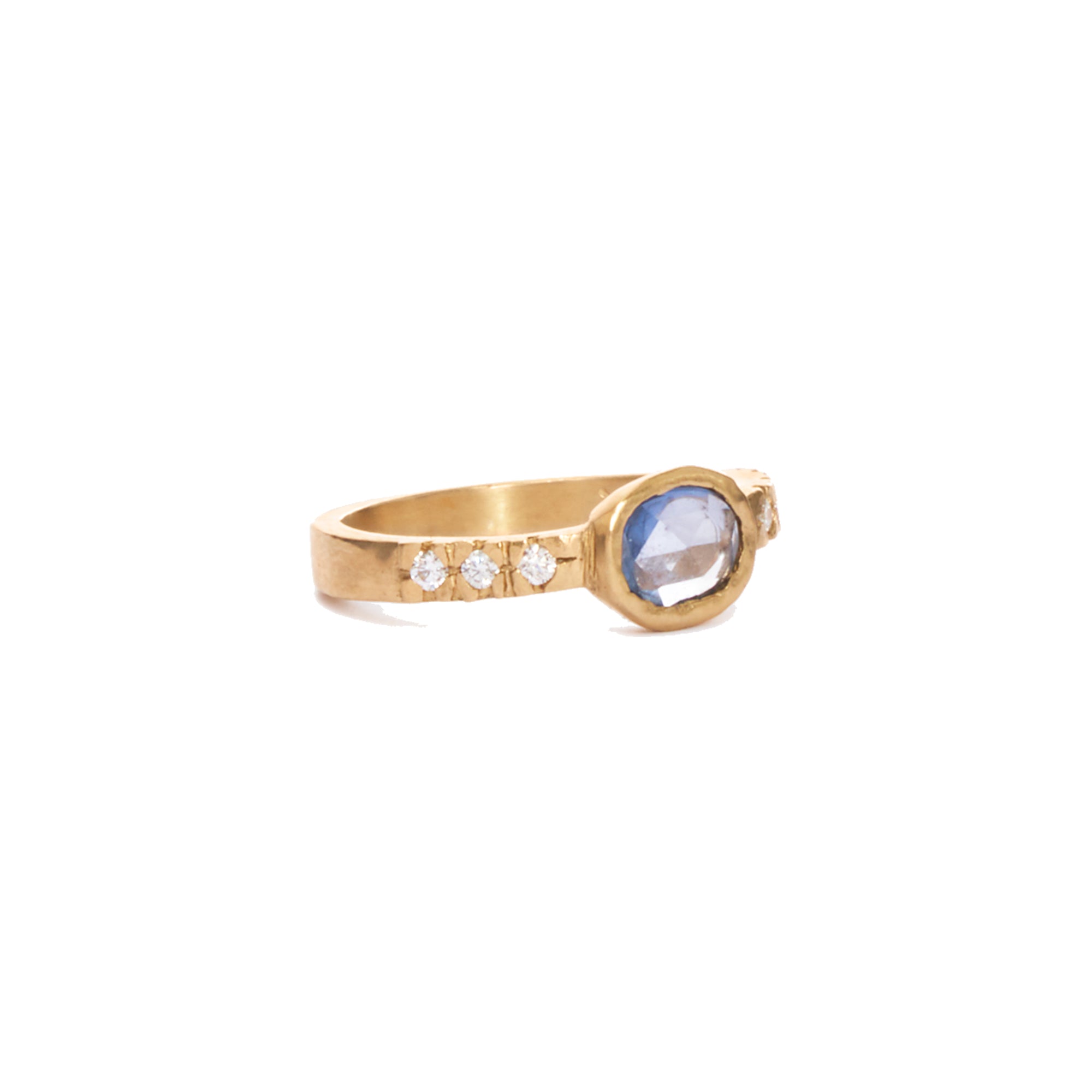 This one of a kind ring features a bezel set oval blue sapphire and six round diamonds, all set in 14k gold. 