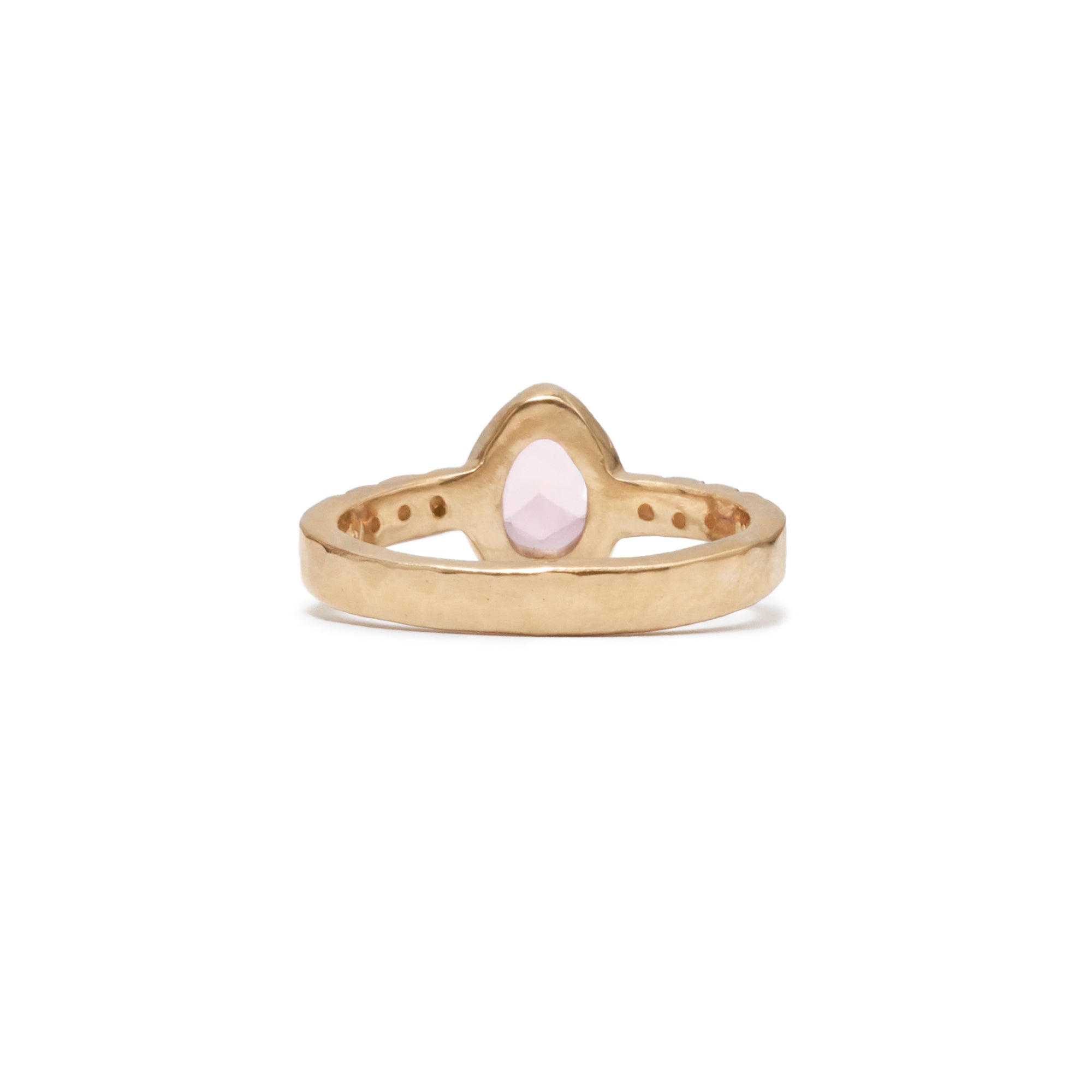 This organic rose cut pink sapphire is bezel set in 14k gold flanked with 3 diamonds set in the band on each side.