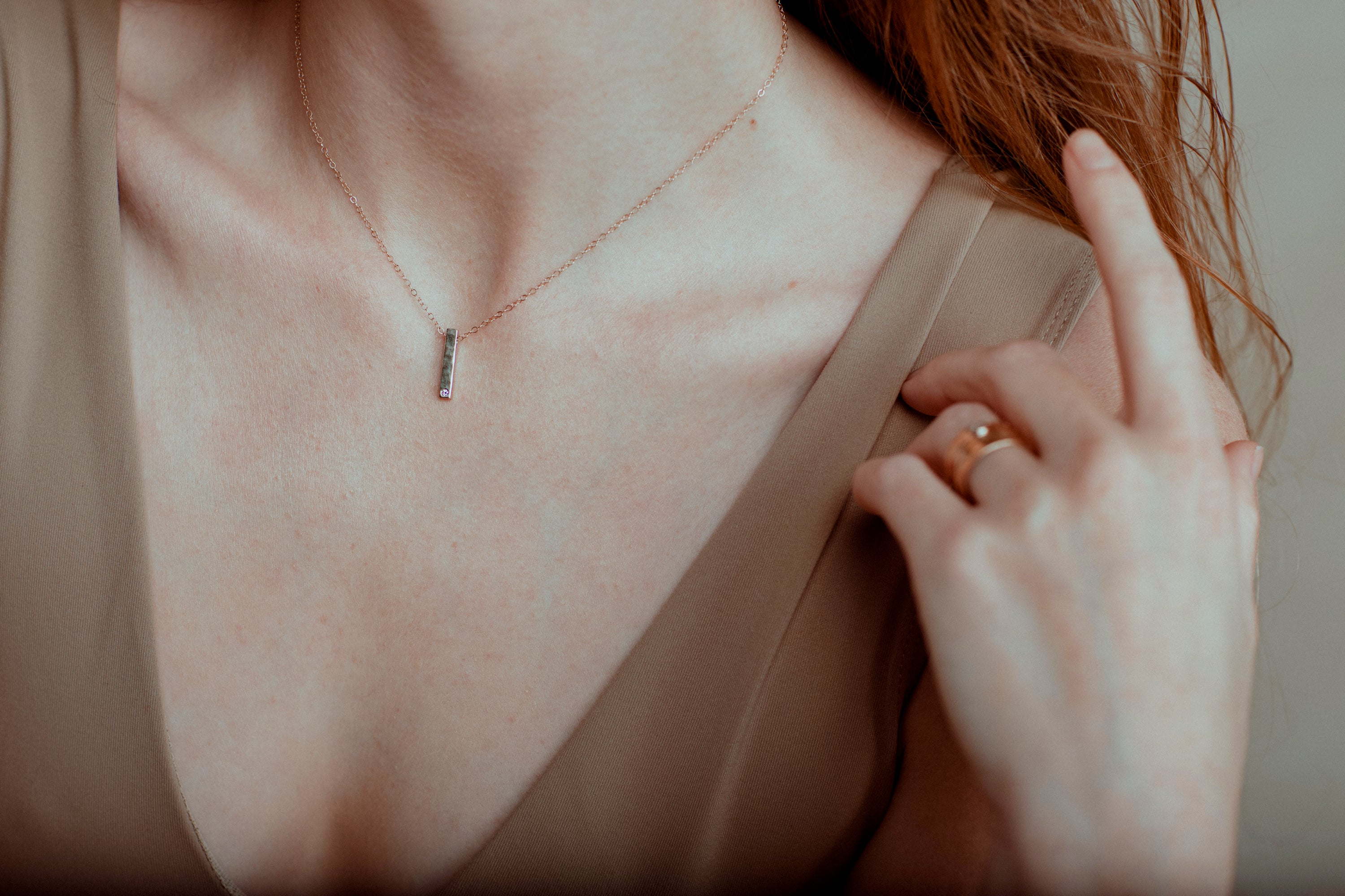 The Classic Bar necklace features a hammered bar pendant with a single 0.02 tcw flush set diamond. 