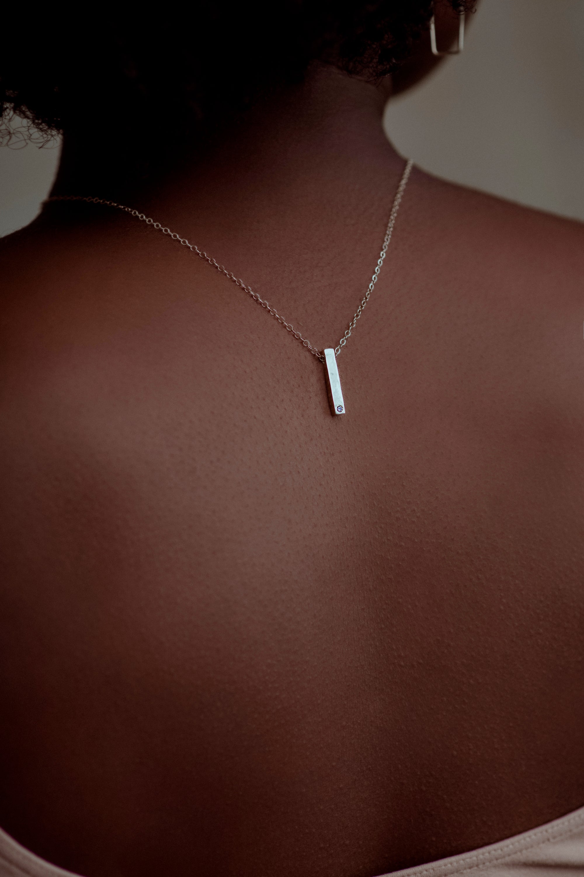 The Classic Bar necklace features a hammered bar pendant with a single 0.02 tcw flush set diamond. 