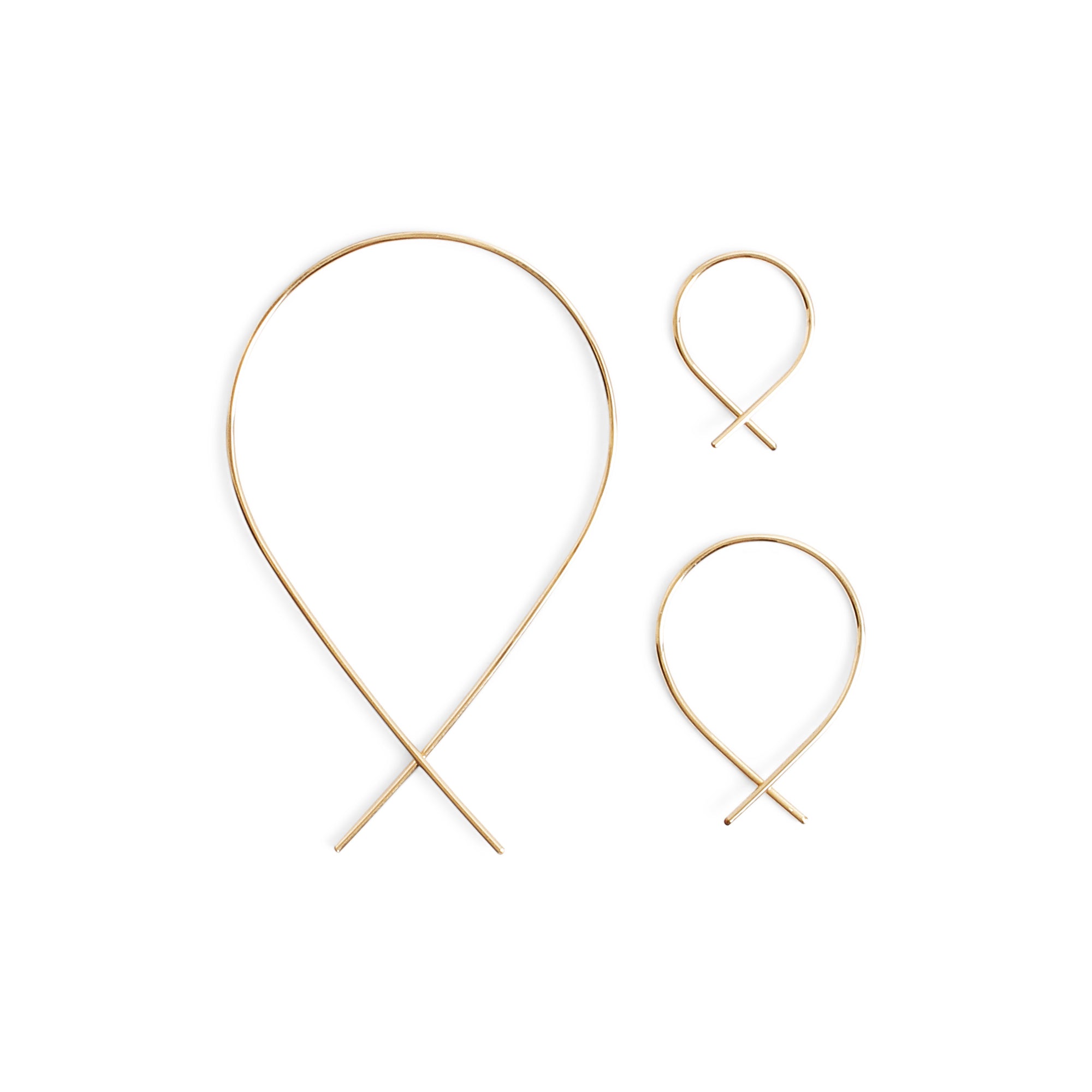 The Fish Earrings are delicate threader earrings feature 14K gold-fill or silver wire shaped into a continuous, open hoop 