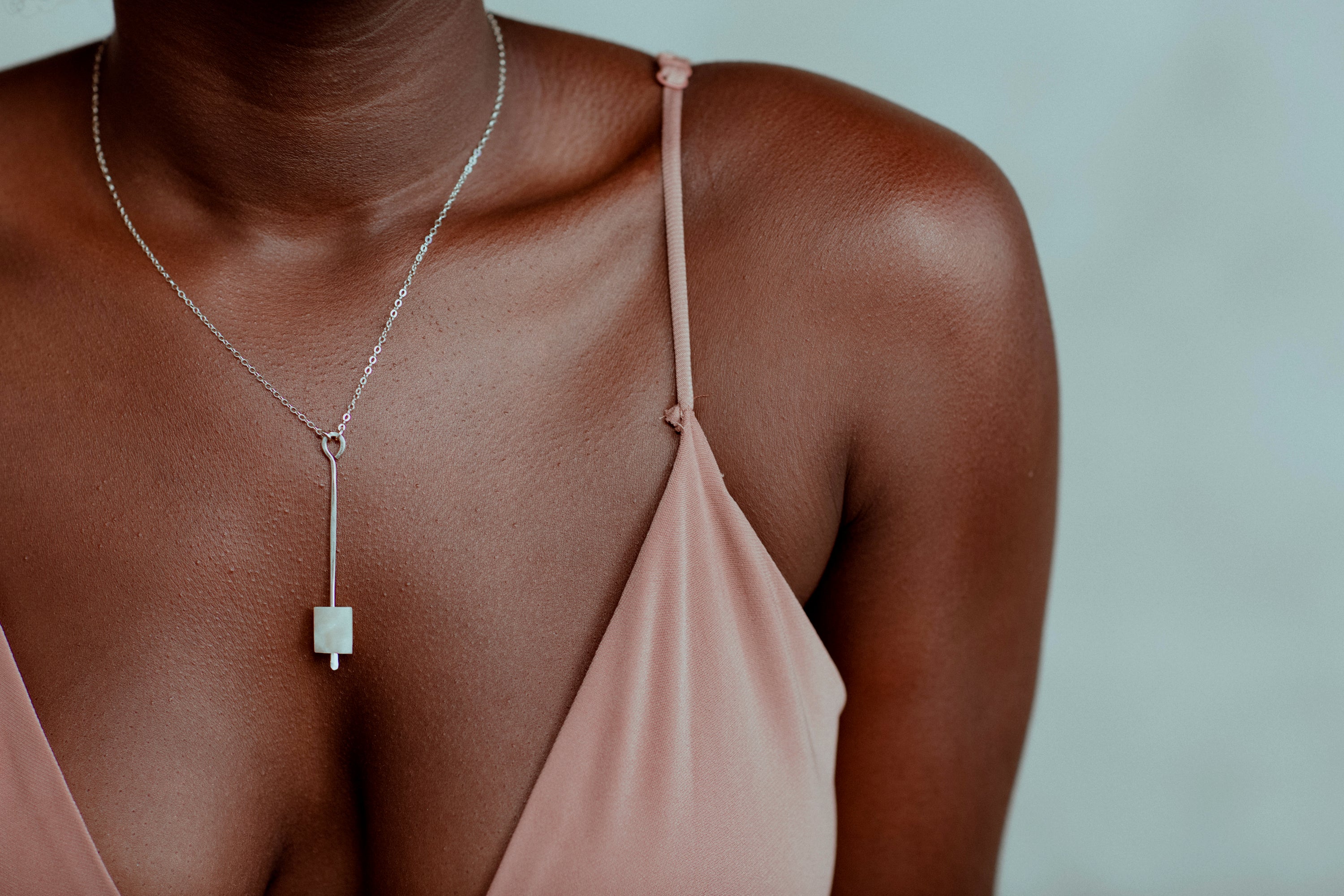 The Pendulum Necklace features frosted onyx suspended from a delicate forged pendant.  